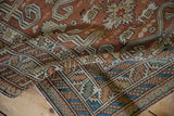 The worn texture and geometric ram's horn motifs of a draped antique Shirvan rug.