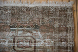 Distressed Hamadan rug corner, showing foundation wear, fringe, and muted ivory, brown, teal.