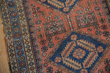 Vintage Heriz rug with dusty blush field, geometric blossoms, pinwheels, and sapphire blue diamond medallion.
