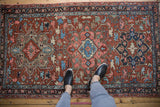 Vintage Heriz rug corner, showing curvilinear Karaja design, gem-tone colors, and pile wear.
