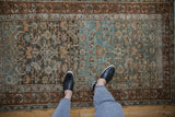 Overhead view showing the distressed, time-softened texture of a vintage Persian Malayer rug.