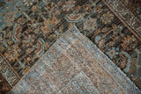 The hand-knotted construction and secure side cord of a distressed Persian Malayer rug.