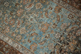 Textured close-up of the distressed Malayer rug showing worn knot heads in blue and chestnut tones.