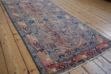Distressed vintage Hamadan runner close-up, highlighting soft rose, blush, and blue organic motifs.