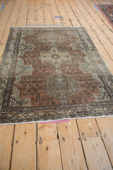 Distressed vintage Karaja rug's lower corner, revealing soft copper, ivory, blue, and geometric pinwheel patterns.