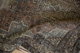 Distressed Karaja rug detail with worn pile and geometric floral motifs in earthy tones.