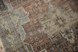 Distressed Karaja rug texture: even wear, faint foundation, geometric patterns. Dusty copper, blue, ivory.
