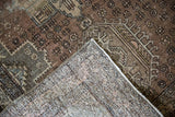 Hand-knotted foundation and distressed brown geometric pattern of the vintage Karaja rug.