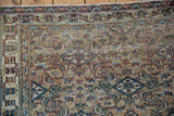 Worn pile and exposed knot heads on the corner of a distressed vintage Khorassan rug.