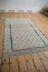 Distressed Malayer rug with lattice of minor medallions in dusty teal, ivory, and coffee brown.