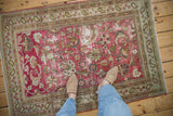 Distressed Doroksh rug corner: magenta field, pale blue paisley, pawn motif, and pile wear.