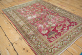 Distressed Doroksh rug corner: magenta field, floral vines, pale blue paisley and pawn borders.