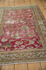 Distressed dusty magenta field with sprawling vines, blossoms, and pawn motif border.