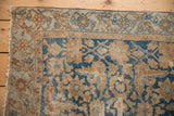 Distressed vintage Malayer rug corner with worn sky blue, terracotta, and ivory Herati floral pattern.