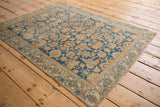 Distressed Malayer rug, showing faded sky blue and terracotta Herati pattern, worn edge.
