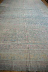 A lengthwise view of the distressed Khotan carpet showing its soft powder blue and pink tones.