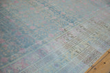 Time-softened patina on a vintage Khotan carpet with powder blue and pink pomegranate motifs.