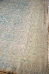 Softly faded border with saffron, pink, and sky blue accents on a vintage Khotan rug.