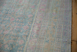 Softly worn texture of a distressed Khotan carpet showing powder blue and pink pomegranate motifs.