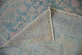 Detail showing the hand-knotted foundation and secured fringe on a vintage distressed Khotan rug.