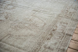 Distressed texture of a vintage Oushak showing low pile, visible knot heads, and pale coffee brown tones.