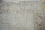 Worn texture of the Samovar border and stepped corner spandrel on a distressed Oushak rug.