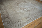 Corner of a distressed Oushak rug showing the Samovar border and time-softened texture.