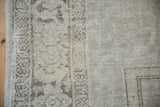 Worn low pile with visible foundation on this vintage Oushak rug's pale coffee brown border.