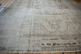 Distressed surface of a vintage Oushak carpet showing low pile and visible knot heads.