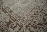 Angled view of the hand-knotted texture and foundation of a distressed Oushak corner.