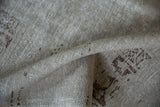 Detailed view of the distressed, low-pile texture showing the visible foundation of a vintage Oushak carpet.