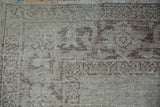 Distressed wear to the knot heads on the corner of a vintage Oushak carpet with ivory fringe.
