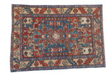 A vintage Karaja rug featuring a serrated diamond medallion in sky blue, red, and sand tones.