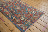 Angled view of a vintage Karaja rug highlighting its geometric motifs and sky blue field.