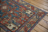 Angled view of the vintage Karaja rug's lighter sand-toned border and serrated motifs.