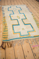 Vintage Moroccan rug side selvage with saffron yellow, dusty turquoise stripes and geometric design.