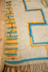 Moroccan rug detail: textured ivory pile, saffron yellow, and turquoise striped selvage.