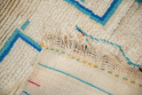 Shaggy ivory pile, striped hand-woven back, and fringe of vintage Moroccan rug.