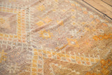 Distressed pile of Moroccan runner, showing saffron geometric patterns and aubergine tones.