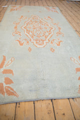 Low perspective of the vintage Moroccan rug's abrashed powder blue and coral pile.