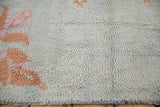 Hand-knotted wool texture showing the pile and knot heads in terracotta, mauve, and blue.