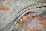 Hand knotted texture with visible pile and knot heads in powder blue, coral, and mauve tones.