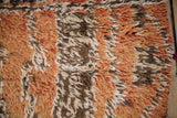 Distressed vintage Moroccan carpet pile with textured burnt orange, chocolate, and ivory yarns.