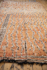 Distressed wool and cotton pile of vintage Moroccan carpet in faded orange, ivory, brown.