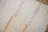 Hand-stitched seams and textured weave of a distressed vintage hemp runner with pale stripes.