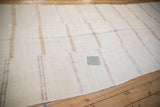 A silver-toned patch showing a storied repair on the textured hemp kilim weave.