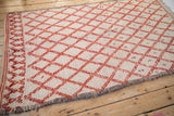 Vintage Moroccan rug's original side selvage, textured ivory pile, and bold red lattice.