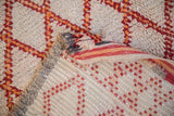 Plain weave reverse of the Moroccan rug, featuring ivory foundation and cherry red square design.