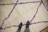 Shaggy ivory pile texture of the Moroccan carpet, with a violet purple diagonal vine.