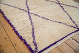 Hand-knotted ivory Moroccan carpet pile with striking violet geometric lines.